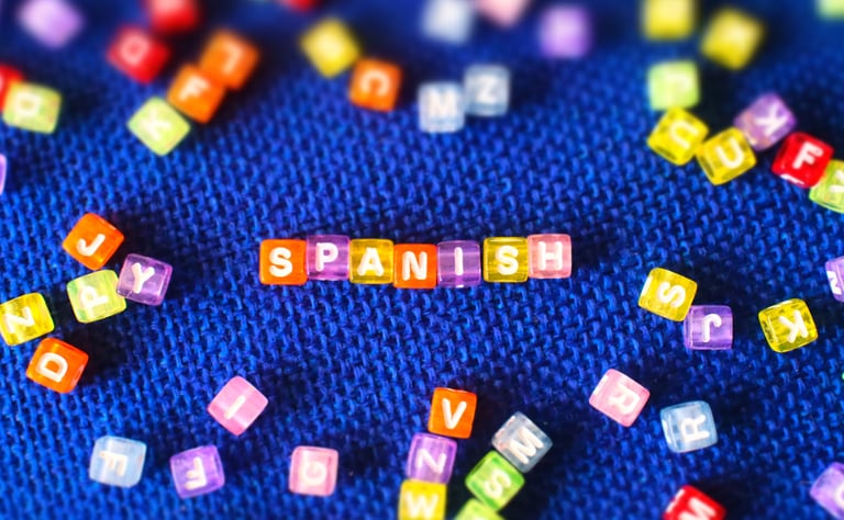 colorful blocks with SPANISH text on blue background, language learning concept