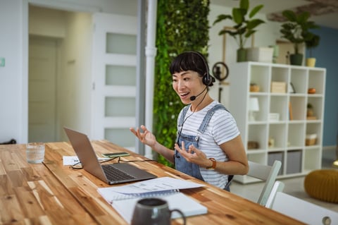 Adult learner with headset engaged in a video call for online language coaching