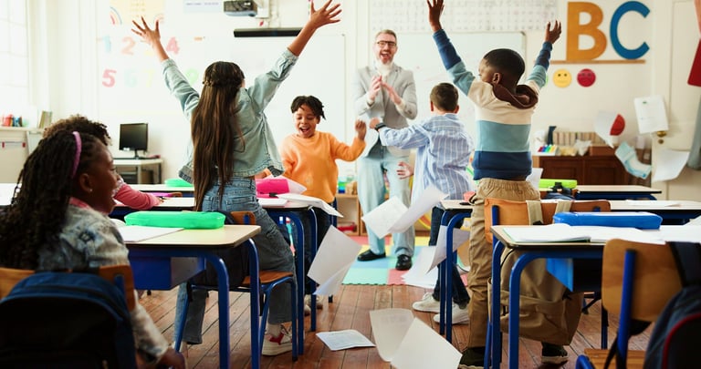 Teacher and students celebrating in classroom