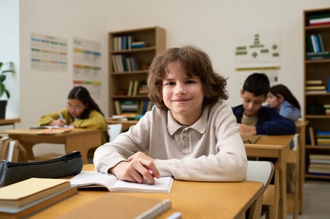 Student sitting at desk smiling and engaged in learning, building confidence through study