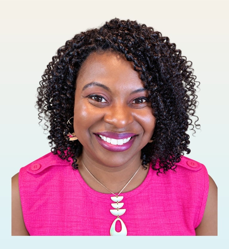 Portrait of a smiling woman with curly black hair wearing a bright pink sleeveless top and shell necklace